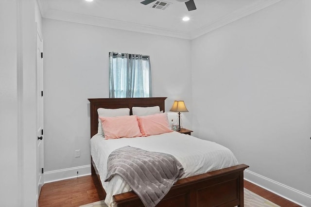 bedroom with hardwood / wood-style flooring, ceiling fan, and ornamental molding