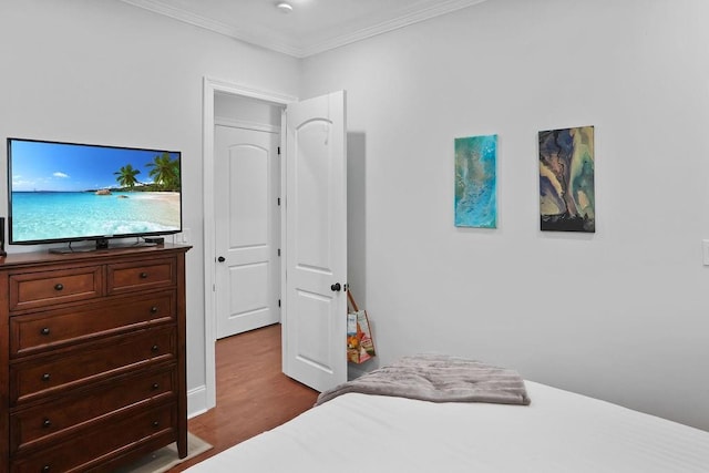 bedroom with hardwood / wood-style flooring and crown molding