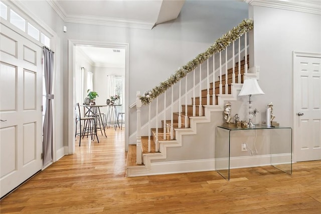 entrance foyer with a healthy amount of sunlight, wood-type flooring, and crown molding