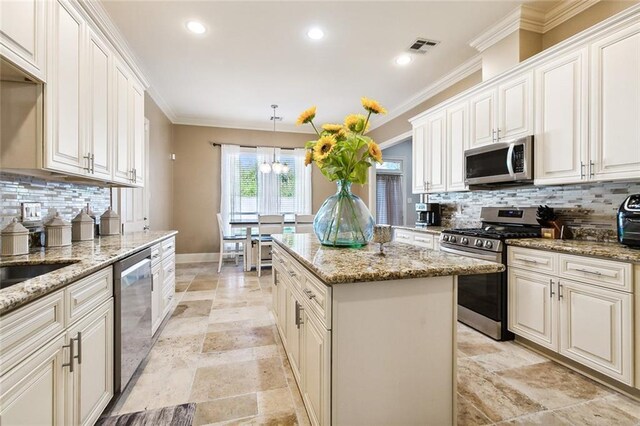 kitchen with backsplash, crown molding, and appliances with stainless steel finishes