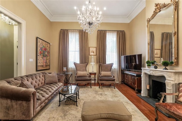 living room featuring crown molding, a high end fireplace, wood-type flooring, and a notable chandelier