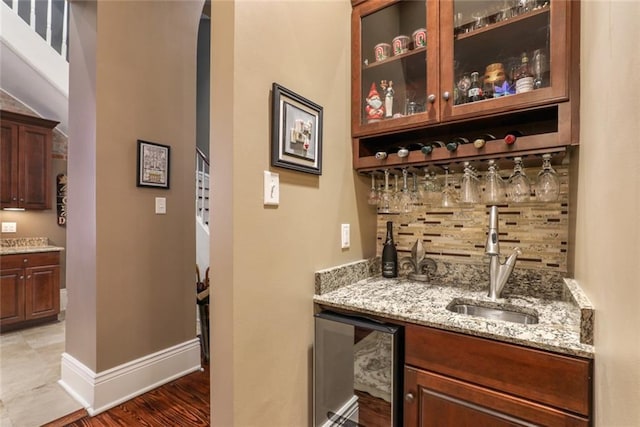 bar featuring decorative backsplash, sink, wine cooler, and light stone counters