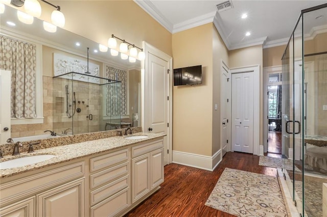 bathroom with hardwood / wood-style floors, vanity, ornamental molding, and independent shower and bath