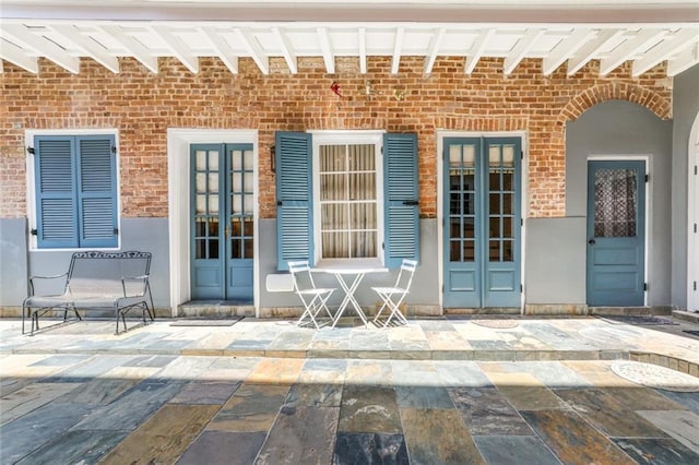 view of exterior entry with a patio area and french doors