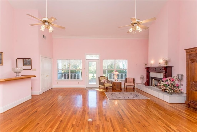 15070 Bruhl Rd, Folsom, LA 70437 - unfurnished living room featuring a tiled fireplace, wood finished floors, ceiling fan, and a towering ceiling