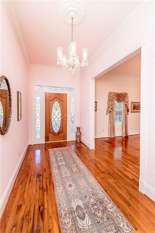 15070 Bruhl Rd, Folsom, LA 70437 - entryway featuring light wood-style flooring, a notable chandelier, baseboards, and ornamental molding
