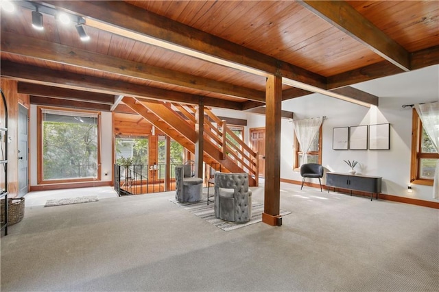 interior space with carpet, beam ceiling, and wooden ceiling