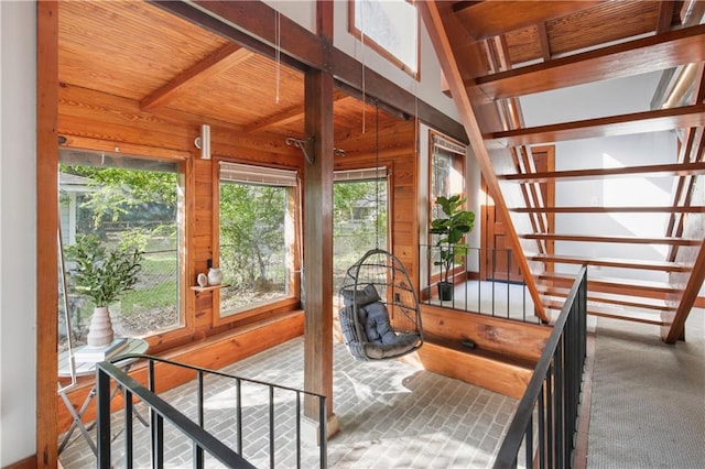 sunroom / solarium featuring vaulted ceiling with beams