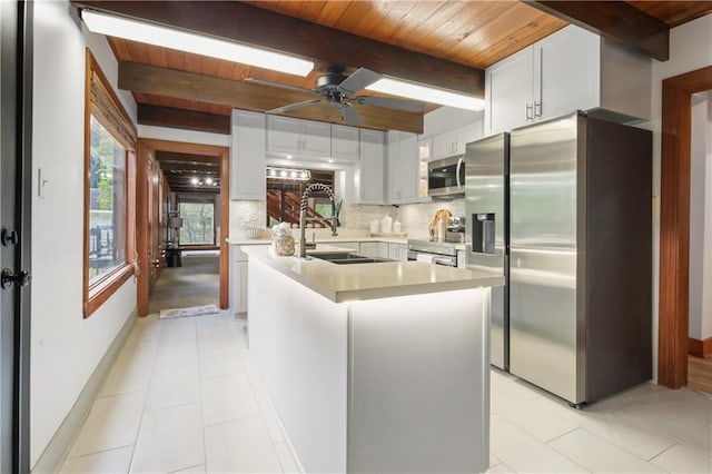 kitchen with stainless steel appliances, a kitchen island, white cabinetry, and ceiling fan