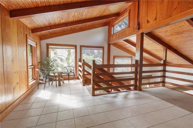 interior space featuring vaulted ceiling with beams, light tile patterned flooring, wood ceiling, and wooden walls