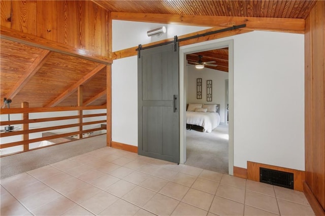 empty room featuring wooden ceiling, lofted ceiling with beams, carpet flooring, ceiling fan, and a barn door