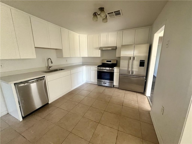 kitchen featuring white cabinetry, sink, light tile patterned floors, and stainless steel appliances