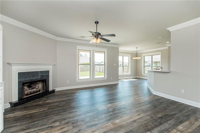 unfurnished living room featuring a high end fireplace, dark wood-type flooring, ceiling fan with notable chandelier, and ornamental molding