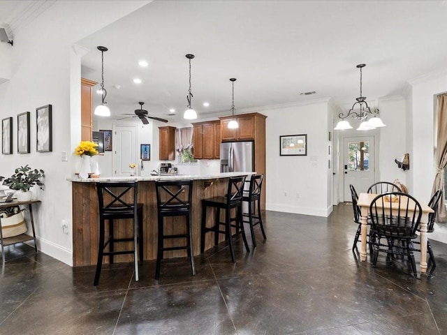 kitchen featuring a kitchen breakfast bar, stainless steel refrigerator with ice dispenser, kitchen peninsula, crown molding, and pendant lighting