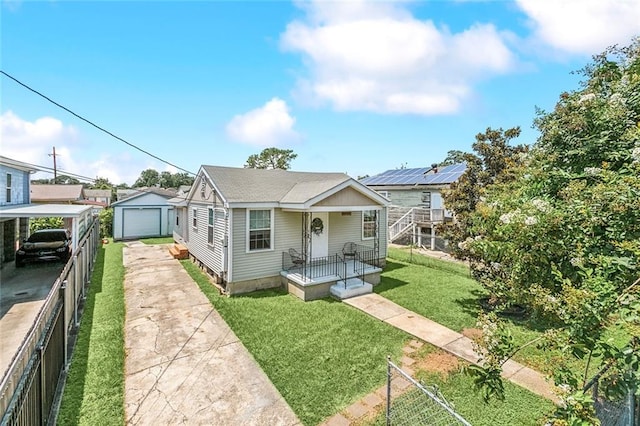 bungalow-style home with a porch, an outbuilding, a front yard, and a garage