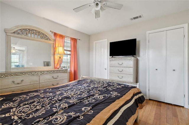 bedroom with a closet, light hardwood / wood-style floors, and ceiling fan