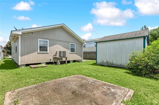 back of house with a yard, a shed, cooling unit, and a patio area