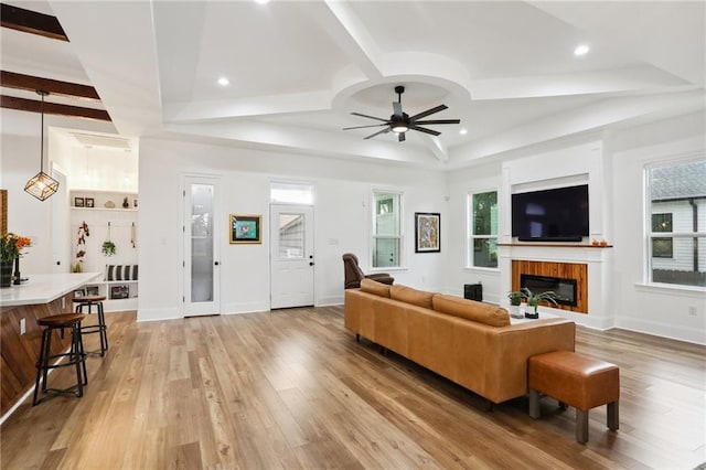 living room with beam ceiling, light hardwood / wood-style floors, and ceiling fan