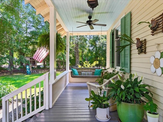 wooden deck featuring covered porch, a yard, and ceiling fan