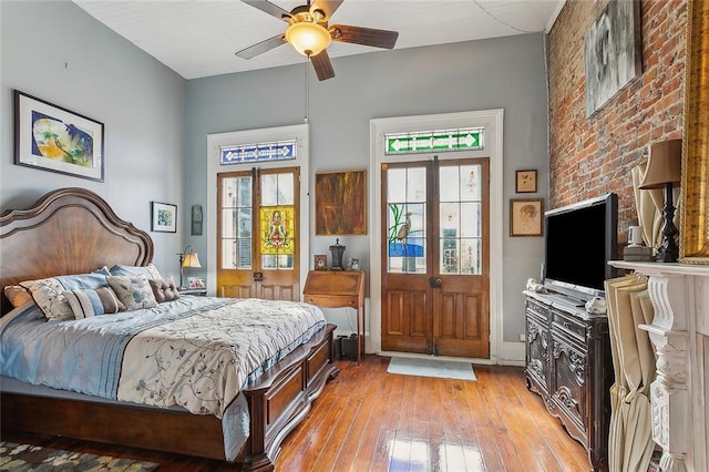 bedroom featuring ceiling fan, light hardwood / wood-style floors, french doors, and multiple windows