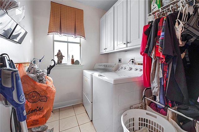 laundry area featuring cabinets, light tile patterned floors, and washer and dryer