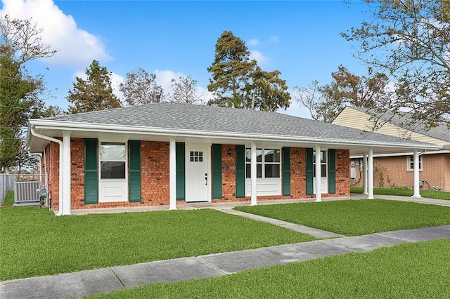 ranch-style home featuring a front yard, cooling unit, and covered porch