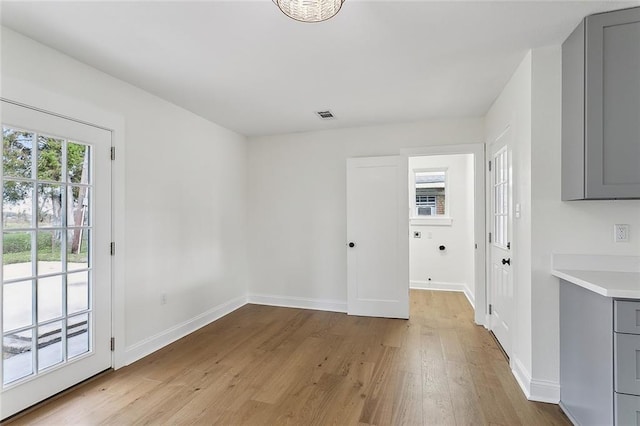 unfurnished dining area featuring light wood-type flooring