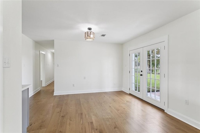 spare room with french doors and light hardwood / wood-style floors