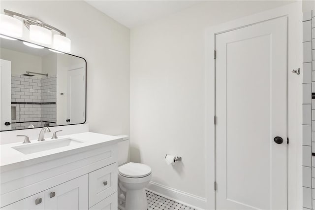 bathroom featuring vanity, toilet, and tiled shower