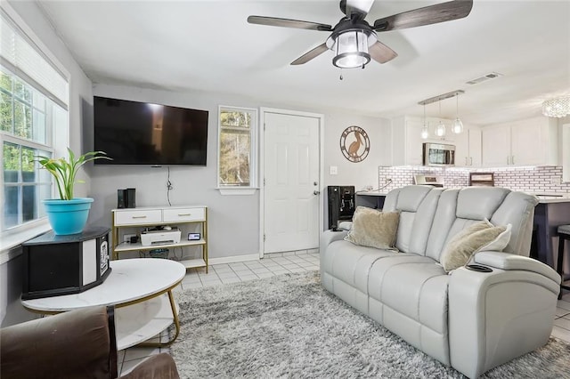 living room with a wealth of natural light, ceiling fan, and light tile patterned floors