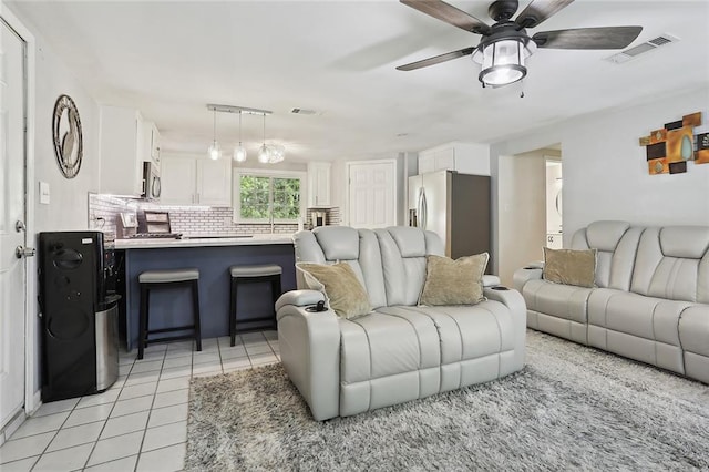 living room featuring light tile patterned floors and ceiling fan