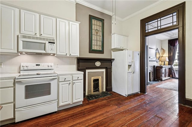 kitchen with crown molding, dark hardwood / wood-style flooring, white cabinets, and white appliances