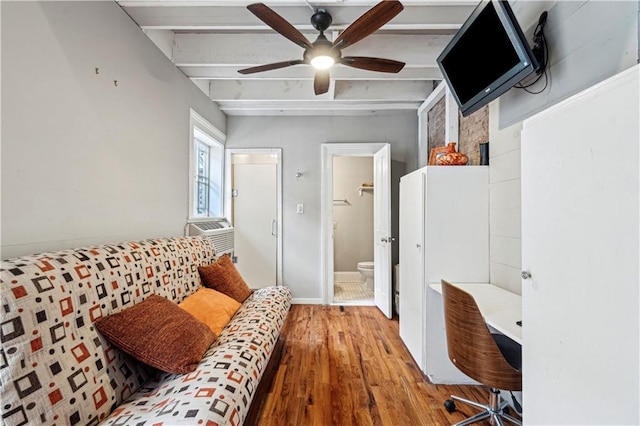 bedroom with ceiling fan, cooling unit, beam ceiling, a spacious closet, and hardwood / wood-style floors