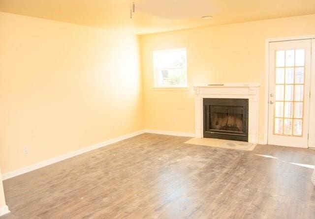 unfurnished living room featuring plenty of natural light and wood-type flooring