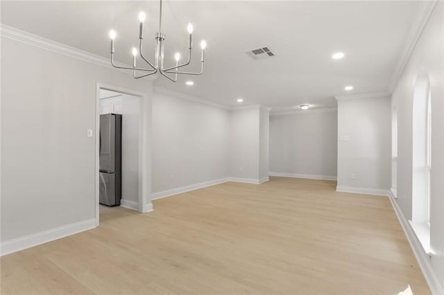 empty room featuring a notable chandelier, light wood-type flooring, and ornamental molding