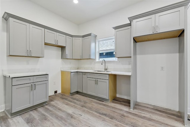 kitchen featuring light hardwood / wood-style flooring, gray cabinetry, and sink