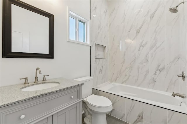 full bathroom featuring vanity, tiled shower / bath combo, and toilet