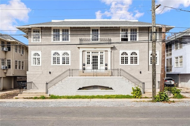 view of front of home featuring stairs, a balcony, and stucco siding