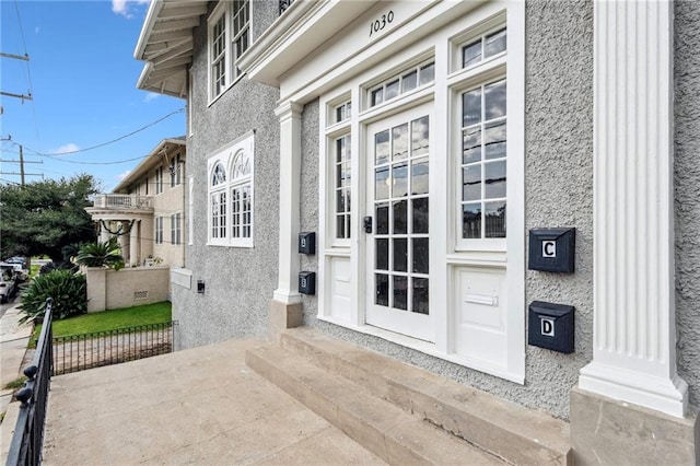 entrance to property featuring stucco siding