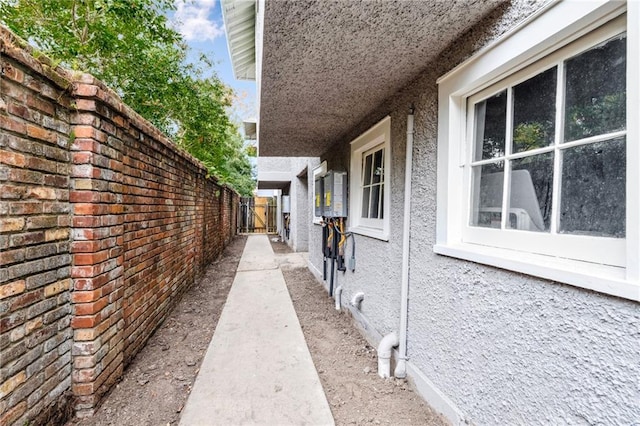 view of home's exterior with stucco siding and fence