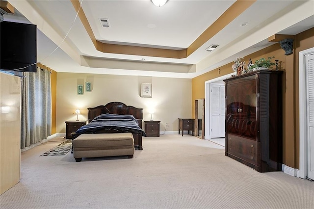 carpeted bedroom with a raised ceiling