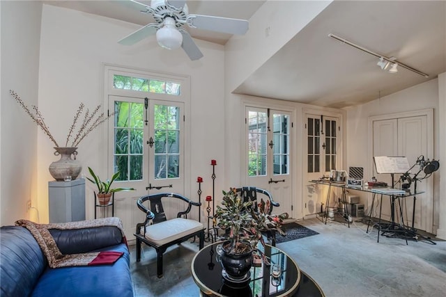 sitting room featuring lofted ceiling, track lighting, french doors, ceiling fan, and concrete floors