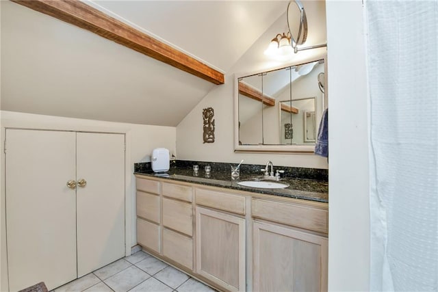 bathroom with tile patterned flooring, vanity, and vaulted ceiling