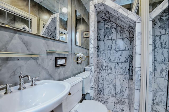 bathroom with toilet, sink, and tile walls