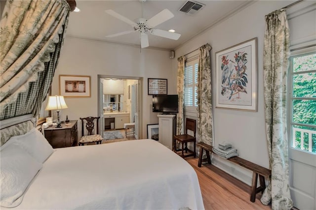 bedroom featuring connected bathroom, light hardwood / wood-style floors, multiple windows, and ceiling fan