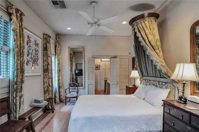 bedroom with ceiling fan, ornamental molding, and light hardwood / wood-style flooring