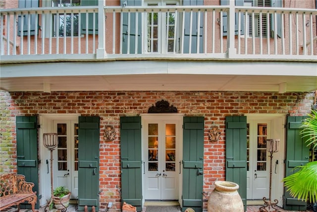 625 Dumaine St, New Orleans, LA 70116 - view of exterior entry featuring covered porch, brick siding, and a balcony
