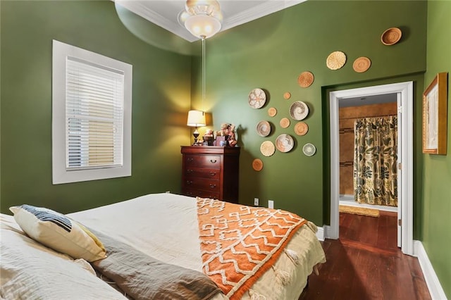 bedroom with ornamental molding, dark hardwood / wood-style flooring, and ensuite bath