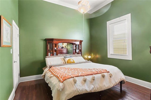 bedroom featuring ceiling fan, ornamental molding, and dark hardwood / wood-style floors