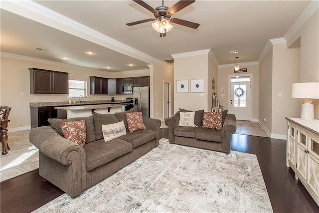 living room featuring crown molding, sink, ceiling fan, and dark wood-type flooring